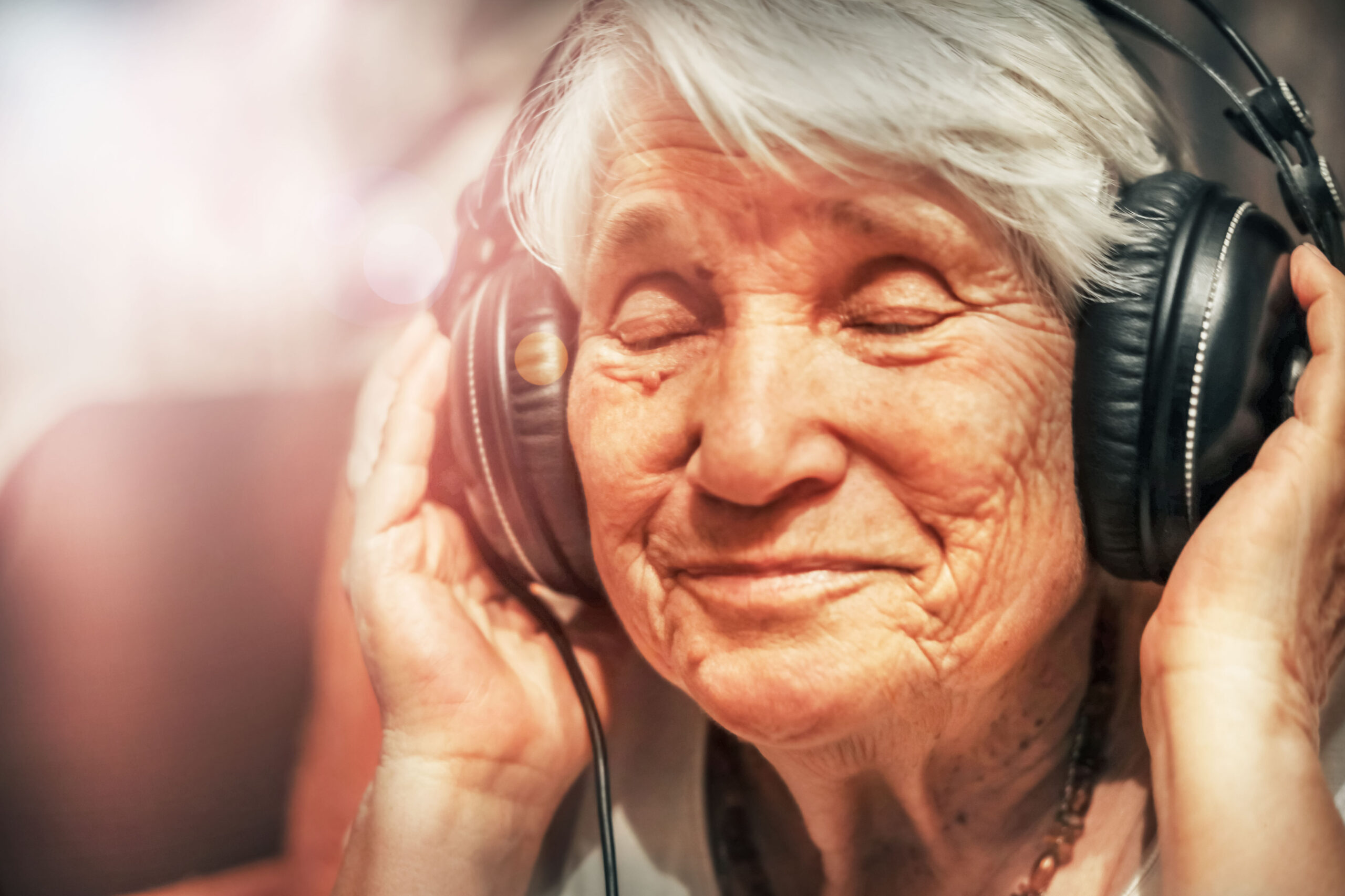 ældre kvinde nyder at høre musik - musik er blandt andet en glæde for mennesker med demens