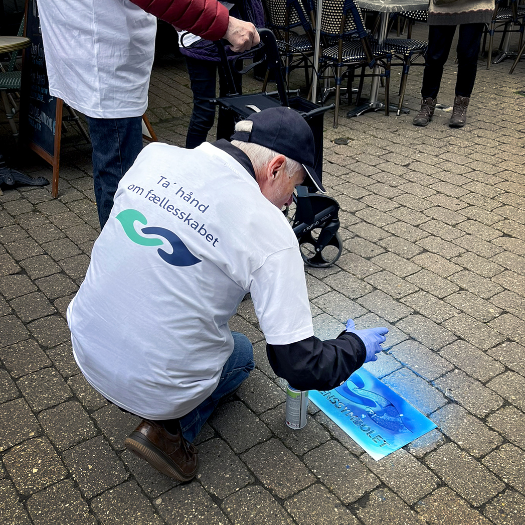 Frivillig sprayer demenssymbol på fortorv